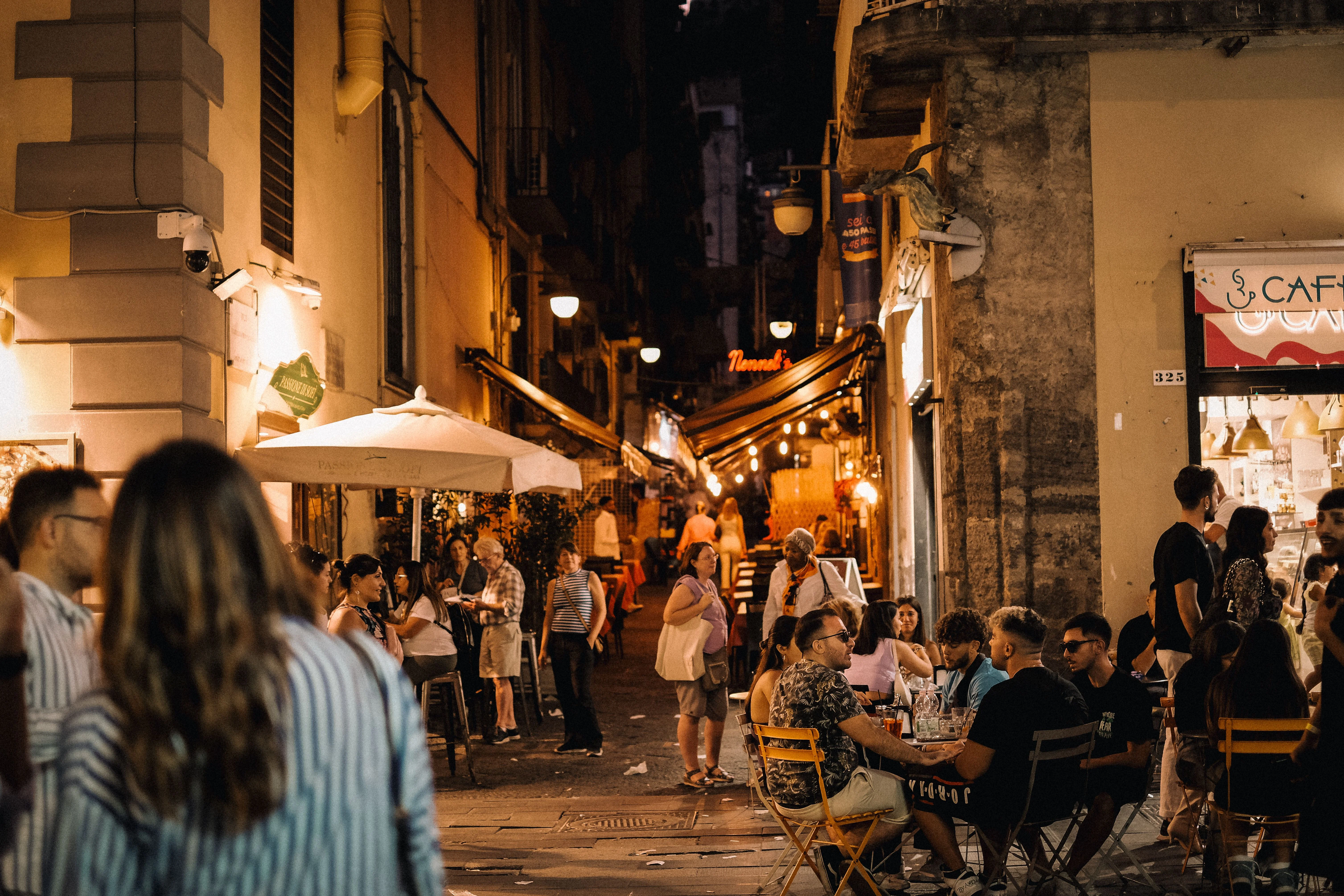 Persone a cena e passeggio in una strada del centro storico