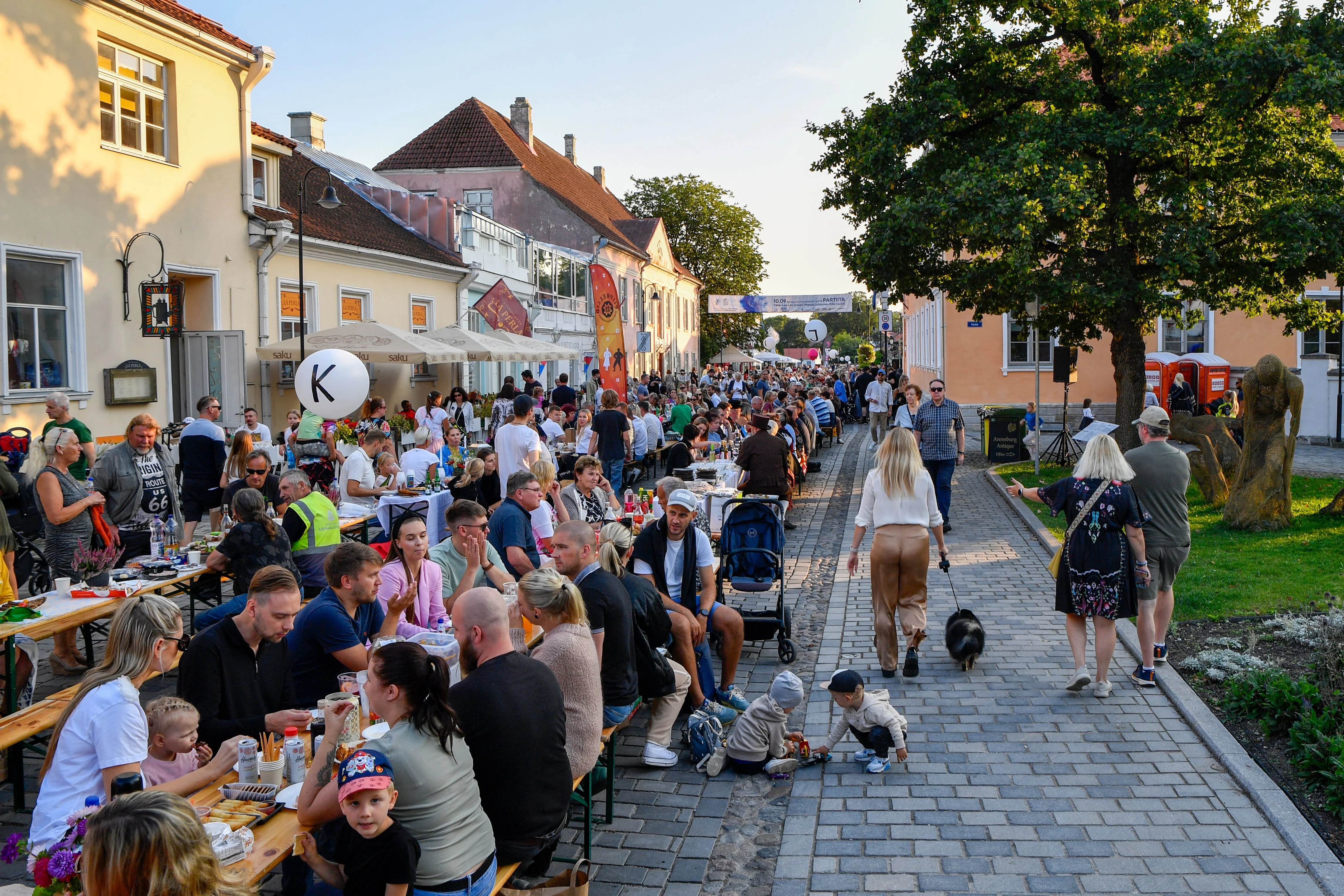 Una strada piena di persone durante una festa di quartiere